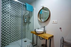 a bathroom with a sink and a shower at Apartamento La Machacona Paneras in Cáceres