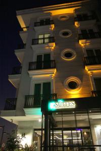 un edificio blanco alto con un cartel delante en K Suites Hotel, en Estambul