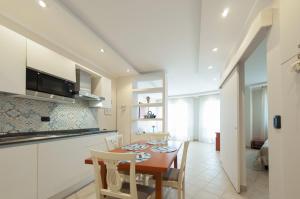 eine Küche und ein Esszimmer mit einem Tisch und Stühlen in der Unterkunft Beverly Park Residence in Tirrenia