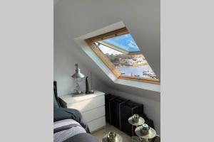 una camera da letto con finestra affacciata sull'acqua di Au Charme d'Audierne -Appartement Vue sur le Port ad Audierne