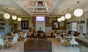 a restaurant with tables and chairs and lights at Kakamas Hotel in Kakamas