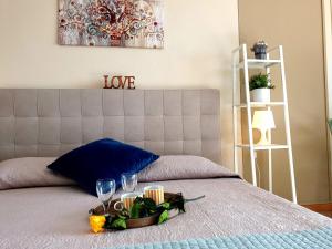 a bed with a tray of flowers and wine glasses at Residence Il Fiore Del Garda in Manerba del Garda