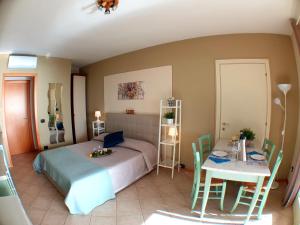 1 dormitorio con 1 cama y 1 mesa con sillas en Residence Il Fiore Del Garda, en Manerba del Garda