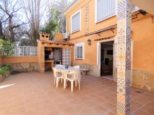 un patio con mesa y sillas frente a una casa en Anacasa Bassetes Playa San Fernando CA550, en Oliva