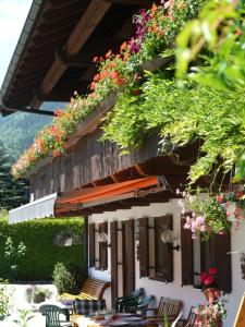 a building with tables and chairs and flowers on it at Gästehaus Taubensee in Oberwössen