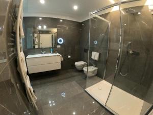 een badkamer met een douche, een wastafel en een toilet bij La Casa sul Lago Lecco 2 in Lecco