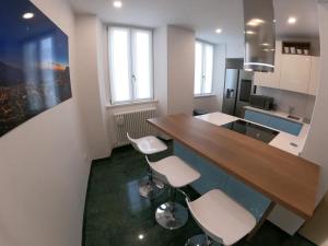 a kitchen with a wooden counter and stools in it at La Casa sul Lago Lecco 2 in Lecco