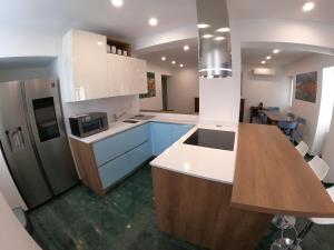 a kitchen with white cabinets and a wooden counter top at La Casa sul Lago Lecco 2 in Lecco +6 photos