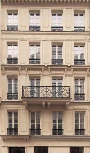 パリにあるオテル ジョージ ワシントンの窓とバルコニー付きの高層ビル
