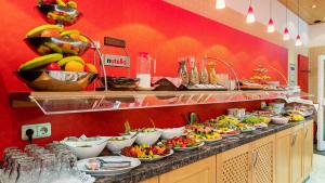 una linea a buffet con molti piatti di frutta e verdura di Hotel Wallis by ANS a Monaco