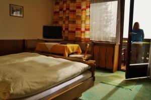 a bedroom with a bed and a table and a television at Landhaus Gletschermühle in Bad Gastein