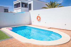 a swimming pool in the backyard of a house at Villa Garoed in Playa Blanca