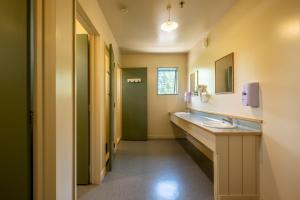 a bathroom with a sink, toilet, and shower at Kakapo Lodge in Hanmer Springs