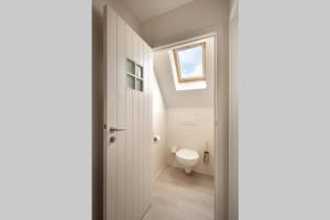 a bathroom with a toilet and a window at Domein Lepelem in De Haan +31 photos