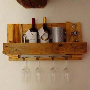 una mensola in legno con bottiglie di vino e bicchieri da vino di Crêuza da me a Genova