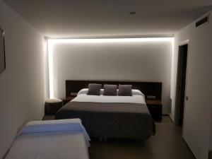 A bed or beds in a room at Hotel Olot Centre