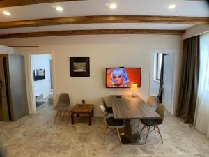 a dining room with a table and a tv on the wall at Zen Apartments Gudauri in Gudauri