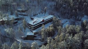 a building with a snow covered roof in the woods at Shangrila Hotels and Resort in Murree