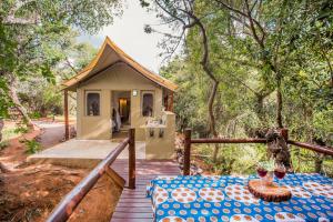 a small tent with a table on a wooden deck at Zwartkloof Adventures Tented Camp in Bela-Bela
