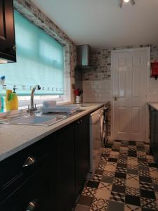 a kitchen with a sink and a counter at Sunrise Cottage in Lowestoft