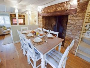 een keuken en eetkamer met een tafel en stoelen bij Thatch Cottage in Todenham