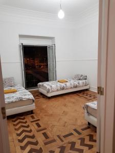 a white room with two beds and a fireplace at Rainbow Guest House in Lisbon