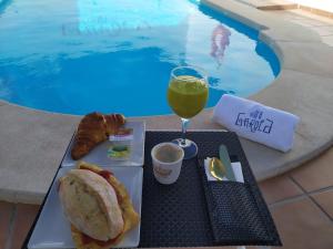una mesa con un sándwich y un vaso de zumo en Villa Garoed, en Playa Blanca