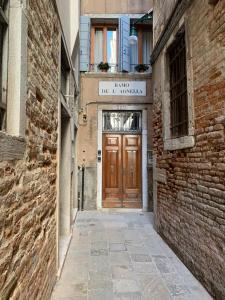 an alley with a wooden door in a building at REGINA - A cosy air conditioned studio just minutes from Rialto in Venice