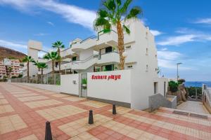 un edificio con una palmera delante en Azahara Playa III, en Arona