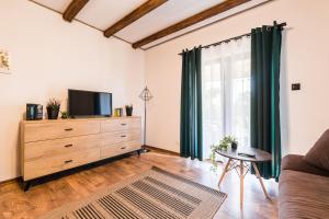 a living room with a television and a dresser at Malinowy Chruśniak Apartamenty in Hoczew