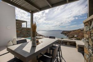 a dining room with a view of the water at Phos Villas Tinos in Agios Romanos