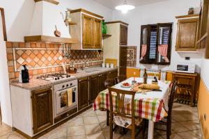 una cucina con tavolo e piano cottura di Locazione Turistica Casa Vento della Toscana a Foiano della Chiana