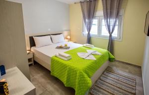 a bedroom with a bed with a green blanket on it at Rent House Diamond in Iraklitsa +284 photos