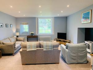 ein Wohnzimmer mit 2 Sofas und einem TV in der Unterkunft The Garden Flat in Charmouth