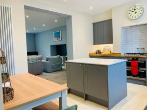 eine Küche und ein Wohnzimmer mit einem Tisch und einer Uhr in der Unterkunft The Garden Flat in Charmouth