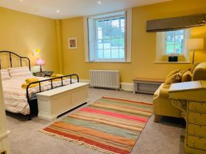 a bedroom with a bed and a couch and a rug at The Garden Flat in Charmouth