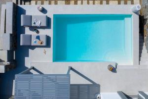 a building with a blue swimming pool and a door at Phos Villas Tinos in Agios Romanos +84 photos