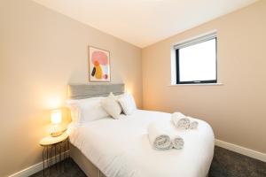 a bedroom with a white bed with towels on it at Penthouse - Harbour Views in Poole
