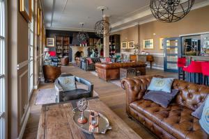 a living room with leather couches and a table at The Starnbergsee Hideaway in Seeshaupt