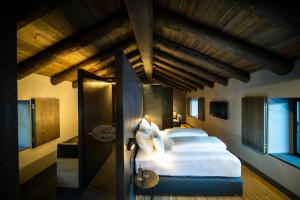 una camera da letto con un grande letto e soffitti in legno di Les Pardines 1819 Mountain suites & SPA a Encamp