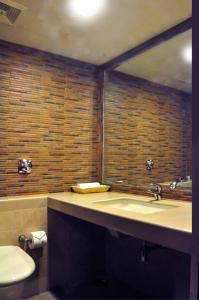 bagno con lavandino e servizi igienici di Abbott Hotel a Navi Mumbai