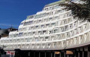 un edificio blanco con balcones en un lateral en TODOSIERRANEVADA ZONA BAJA - APARTAMENTOS DE 4 DORMITORIOS - Junto a los Telecabinas, en Sierra Nevada