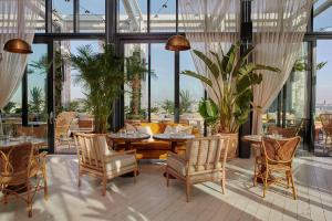 a restaurant with tables and chairs and large windows at The Hoxton, Southwark in London