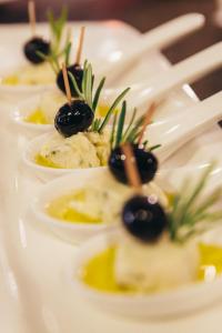 a row of appetizers on a plate with olives at Alpinhotel Pacheiner in Treffen