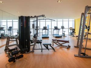 a gym with several tread machines in a room at Pullman Sharjah in Sharjah