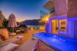 a villa with a swimming pool and a house at Peninsula Gardens Hotel in Kas