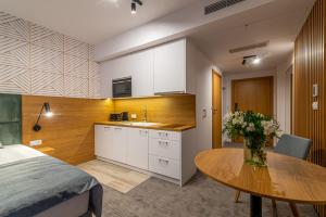 a kitchen and dining room with a table and a bed at Seaside Apartaments Deluxe 627 in Kołobrzeg