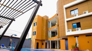 a view of a building with a swimming pool at Hotel La Casa Cielo in Cotonou