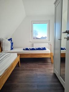 una camera da letto con due letti e una finestra di Wohnung "Burgtiefe" in Bannesdorf auf Fehmarn a Fehmarn