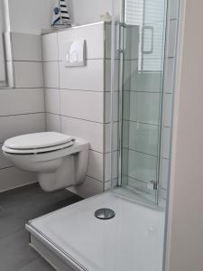 un bagno con wc e doccia in vetro di Wohnung "Burgtiefe" in Bannesdorf auf Fehmarn a Fehmarn Altre 14 foto